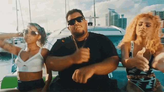 a man in a black shirt is dancing with two women