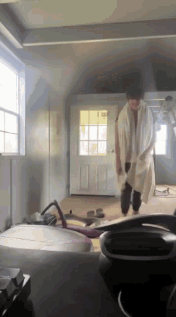 a person with a towel around their neck is walking in a room