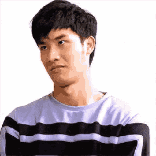 a young man in a striped sweater is making a funny face .