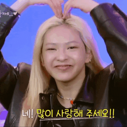 a woman making a heart shape with her hands on her head