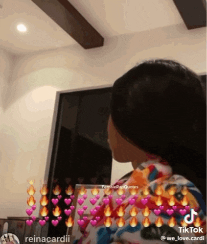 a woman is sitting in a living room with hearts and fires around her