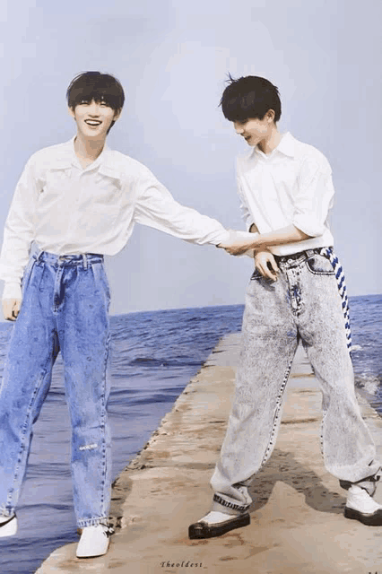 two boys holding hands on a pier with the words the oldest written on the bottom