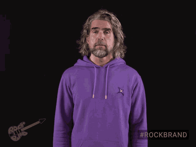 a man wearing a purple hoodie with a blue star embroidered on it