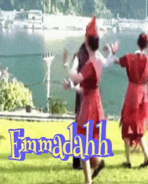 a group of people are dancing in front of a body of water with the name emmadah