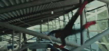 a man in a spiderman costume is falling through a building .