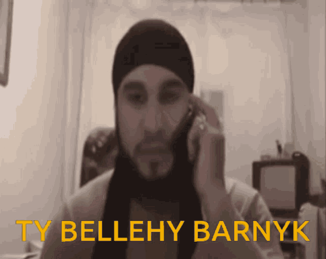 a man talking on a cell phone with the words ty bellehy barnyk written above him