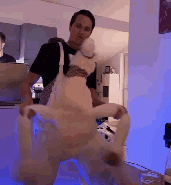 a man is standing next to a stuffed animal that is on its back