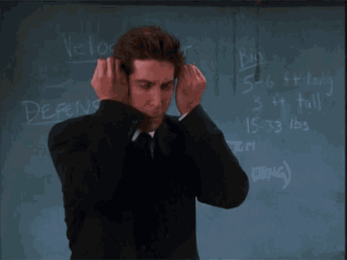 a man covering his ears with his hands in front of a blackboard that says " definition "