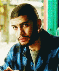 a man with a beard wearing a blue jacket looks at the camera