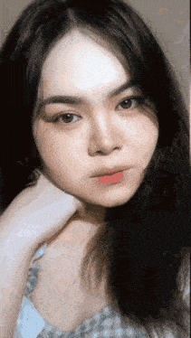 a woman with long black hair is looking at the camera