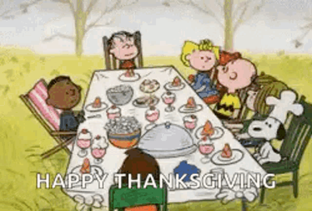 a group of peanuts characters are sitting around a table with a chef .