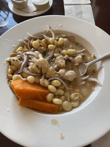 a plate of food with beans and carrots on a table
