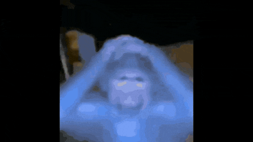 a blurry picture of a person 's face with their hands on their head