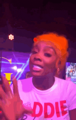 a woman with orange hair is wearing a t-shirt that says ' odie ' on it