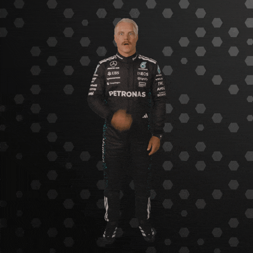 a man in a petronas racing suit is making a surprised face