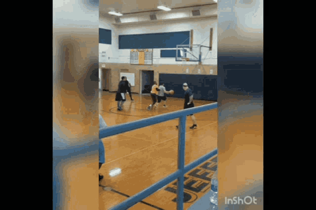 a group of people are playing basketball in a gym with the word inshot on the bottom right