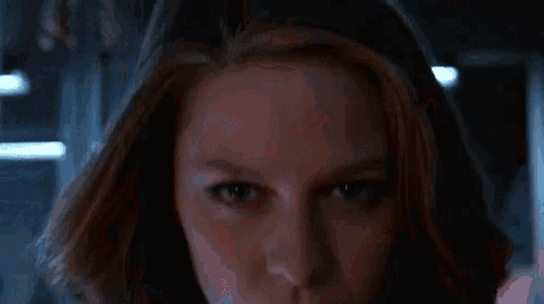 a close up of a woman 's face with red blood coming out of her eyes