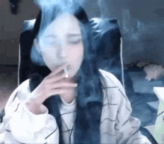 a woman is sitting in a chair smoking a cigarette .