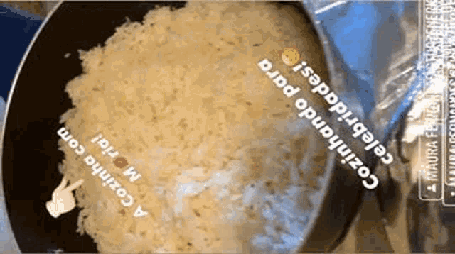 a bag of rice is being cooked in a frying pan with a hand pointing at it .