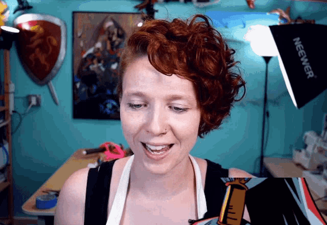 a woman is smiling in front of a neewer lamp