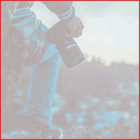 a person holding a camera in their hand with a key hanging from their belt