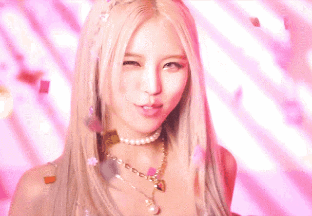 a woman with blonde hair is wearing a pearl necklace and earrings