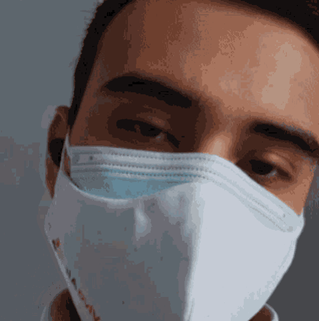 a close up of a man wearing a face mask with a rainbow on it