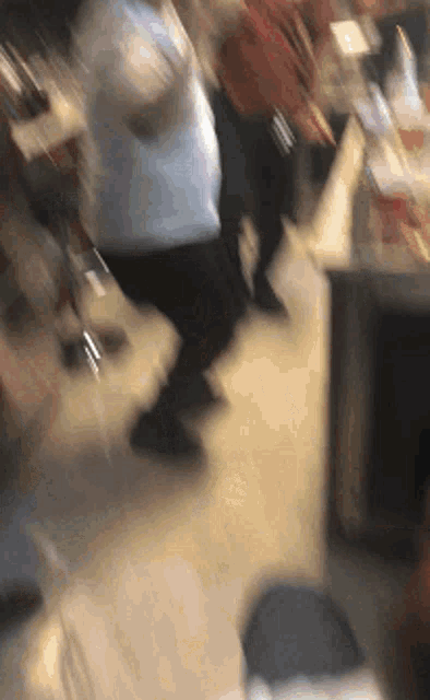 a blurry picture of a crowd of people walking in a room .