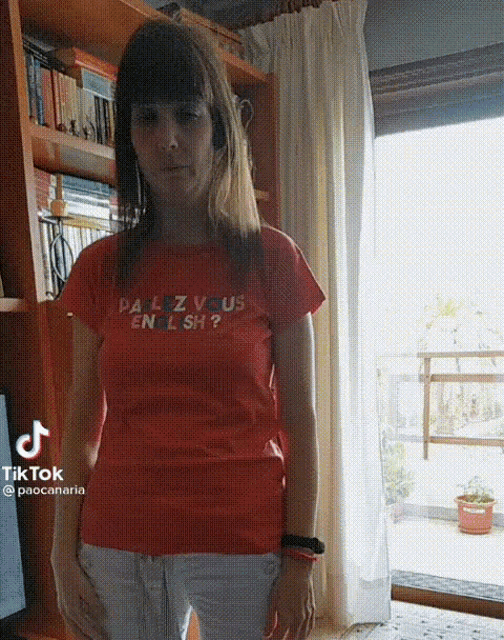 a woman wearing an orange t-shirt that says " palzvous english "