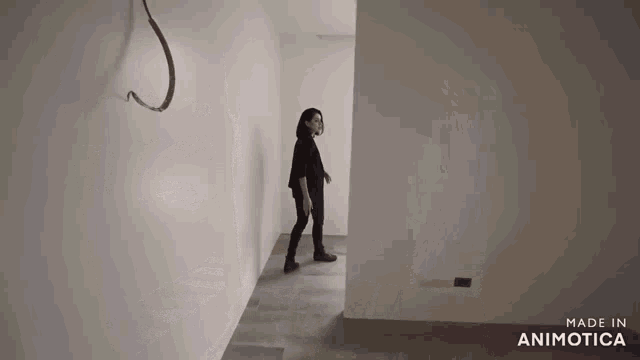 a woman standing in an empty room with the words made in animatica on the bottom