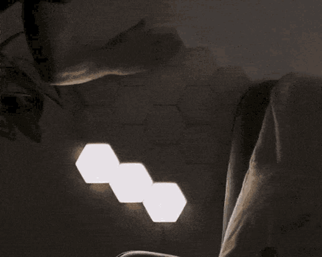 a person is sitting in a chair with a glowing hexagon on the wall behind them