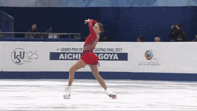 a woman in a red dress is ice skating in front of a sign that says grand prix of skating final 2017