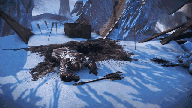 a man is laying in the snow holding a spear