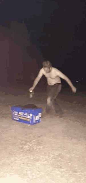 a man without a shirt is standing next to a pepsi cooler