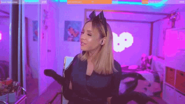 a woman in a catsuit is dancing on a purple background .