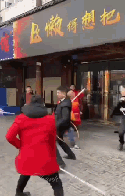 a man in a red jacket stands in front of a store with chinese writing