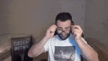 a man wearing glasses and a t-shirt with a picture of a boat on it .