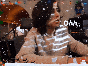 a man in a striped sweater says ohh in front of a snowy scene