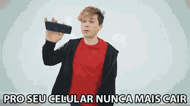 a man in a red shirt holds up a cell phone with the words pro seu celular nunca mais cair written below him