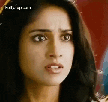 a close up of a woman 's face with a surprised expression on her face .