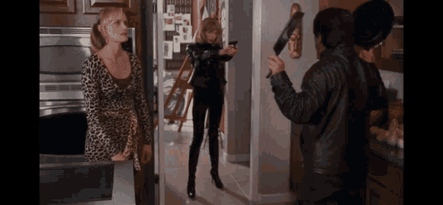 a woman in a leopard print dress holds a gun while a man in a leather jacket holds a knife