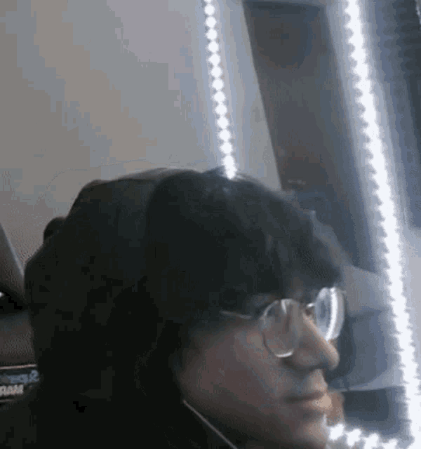 a man wearing glasses and headphones is sitting in front of a ram logo