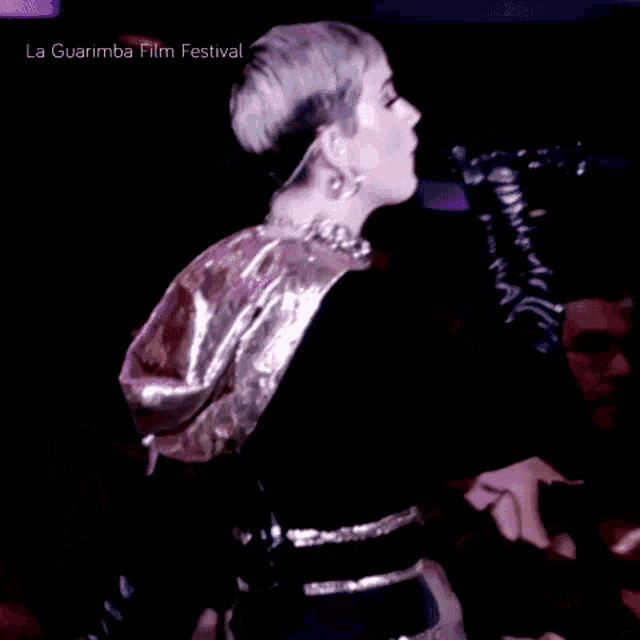 a woman is dancing in front of a crowd with the words la guarimba film festival below her