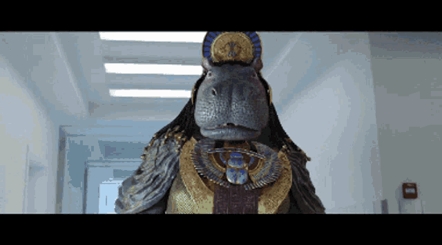 a statue of a hippo wearing a necklace and a crown
