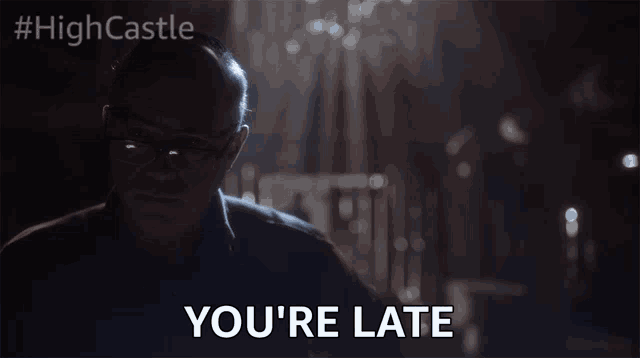 a man wearing glasses says " you 're late " in a dark room