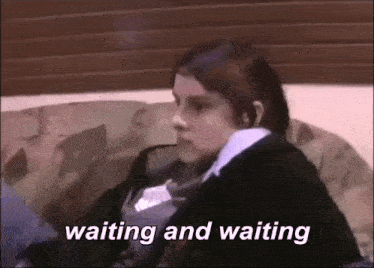 a girl is sitting on a couch with the words waiting and waiting written below her .