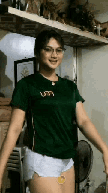 a woman wearing glasses and a green shirt with the word uer on it