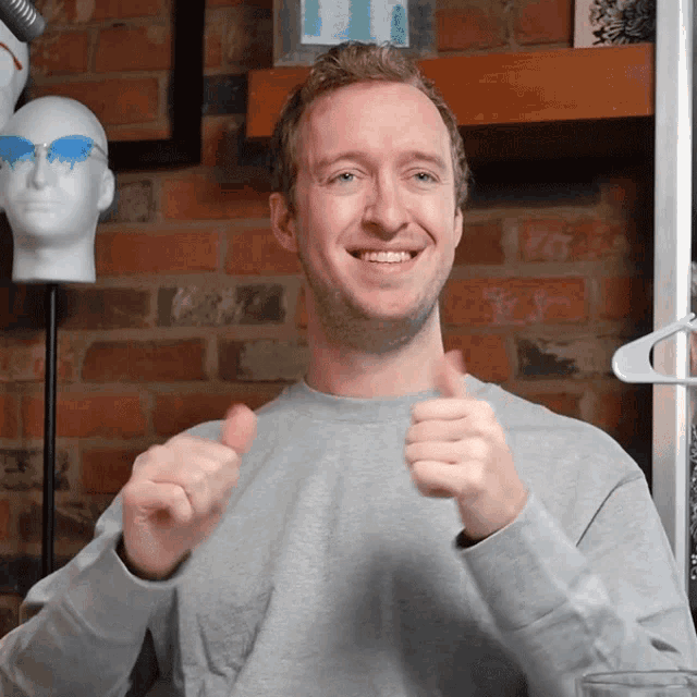 a man giving a thumbs up in front of a mannequin head