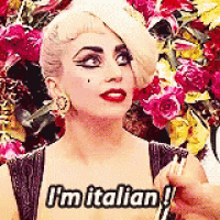 a woman is holding a fork in her hand and says `` i 'm italian '' .