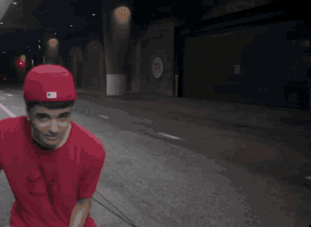 a man wearing a red hat and a red shirt is standing on a street